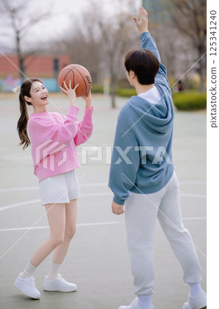 A young couple enjoying a basketball date in the park 125341240