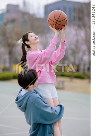 A young couple enjoying a basketball date in the park A young couple enjoying a basketball date in the park 125341248
