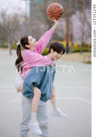 A young couple enjoying a basketball date in the park 125341249
