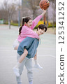 A young couple enjoying a basketball date in the park 125341252