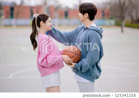 A young couple enjoying a basketball date in the park A young couple enjoying a basketball date in the park 125341258