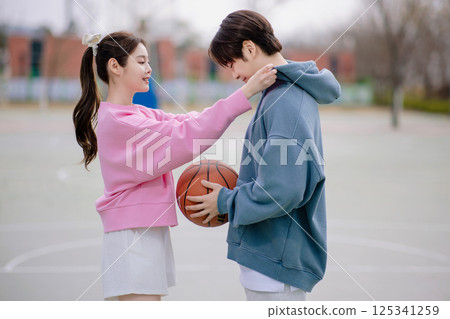 A young couple enjoying a basketball date in the park 125341259