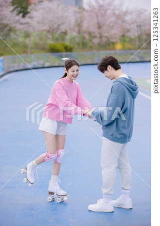 Couple skating in the park Couple skating in the park 125341263