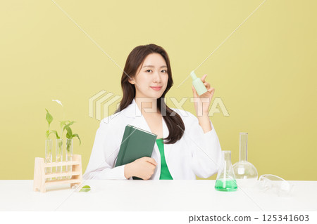 A woman wearing a doctor's gown is holding eco-friendly cosmetics A woman wearing a doctor's gown is holding eco-friendly cosmetics 125341603