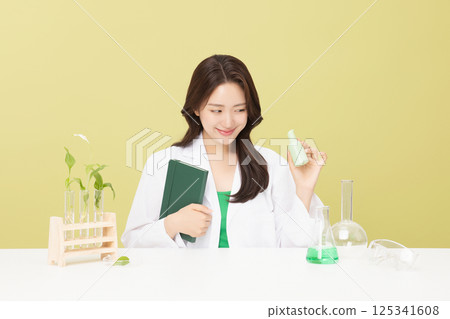 A woman wearing a doctor's gown is holding eco-friendly cosmetics 125341608