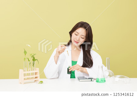 A woman wearing a doctor's gown is holding eco-friendly cosmetics 125341612