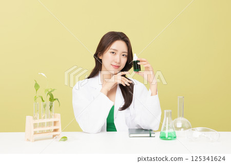 A woman wearing a doctor's gown is holding eco-friendly cosmetics A woman wearing a doctor's gown is holding eco-friendly cosmetics 125341624
