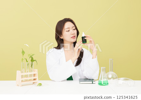 A woman wearing a doctor's gown is holding eco-friendly cosmetics 125341625