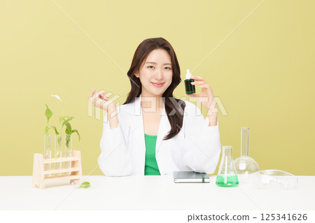 A woman wearing a doctor's gown is holding eco-friendly cosmetics A woman wearing a doctor's gown is holding eco-friendly cosmetics 125341626