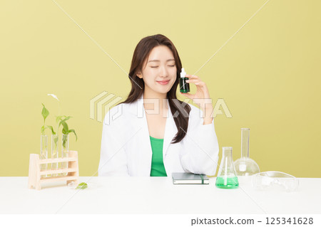 A woman wearing a doctor's gown is holding eco-friendly cosmetics 125341628