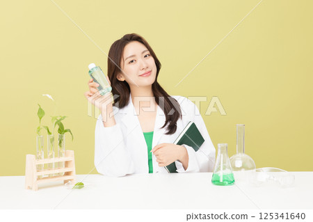 A woman wearing a doctor's gown is holding eco-friendly cosmetics 125341640