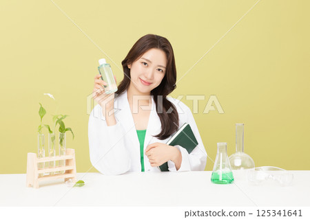 A woman wearing a doctor's gown is holding eco-friendly cosmetics 125341641