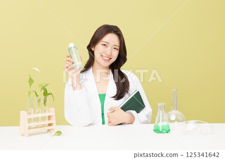 A woman wearing a doctor's gown is holding eco-friendly cosmetics 125341642