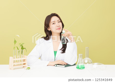 A woman wearing a doctor's gown is holding eco-friendly cosmetics 125341649