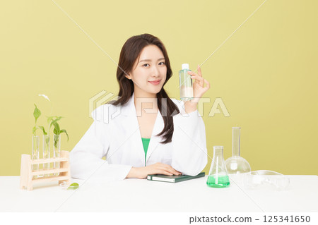 A woman wearing a doctor's gown is holding eco-friendly cosmetics 125341650