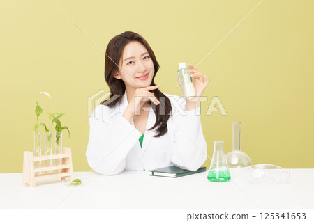 A woman wearing a doctor's gown is holding eco-friendly cosmetics 125341653