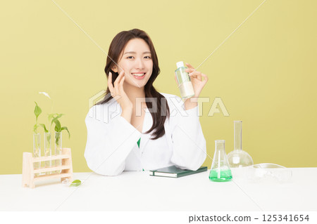 A woman wearing a doctor's gown is holding eco-friendly cosmetics 125341654
