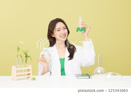 A woman wearing a doctor's gown is holding eco-friendly cosmetics 125341663