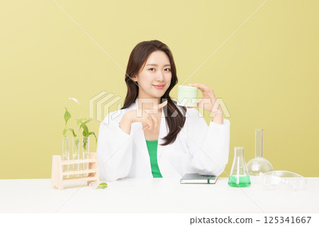 A woman wearing a doctor's gown is holding eco-friendly cosmetics 125341667