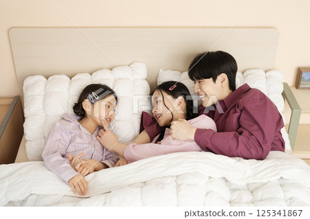 A family gathered in the living room doing their own thing A family gathered in the living room doing their own thing 125341867