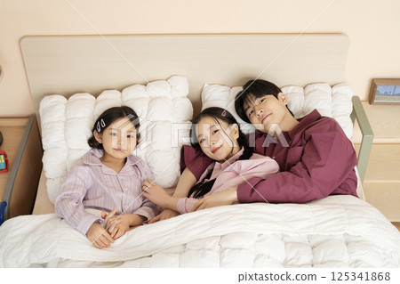 A family gathered in the living room doing their own thing A family gathered in the living room doing their own thing 125341868