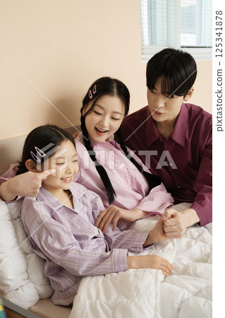 A family gathered in the living room doing their own thing A family gathered in the living room doing their own thing 125341878
