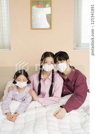 A family of three sitting affectionately together on the living room sofa A family of three sitting affectionately together on the living room sofa 125341891