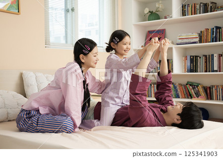 A family of three sitting affectionately together on the living room sofa A family of three sitting affectionately together on the living room sofa 125341903