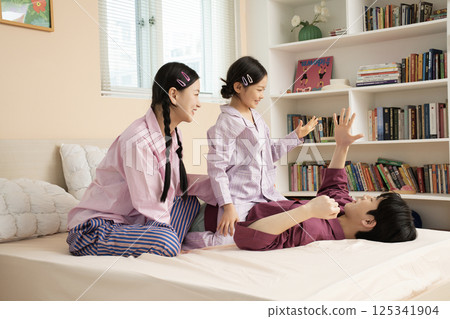 A family of three sitting affectionately together on the living room sofa 125341904