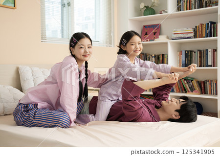 A family of three sitting affectionately together on the living room sofa 125341905