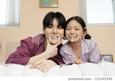 A family looking at an iPad while unpacking their suitcase 125341949