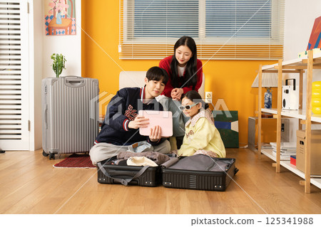 Extroverted family sitting on the sofa and taking a selfie together 125341988