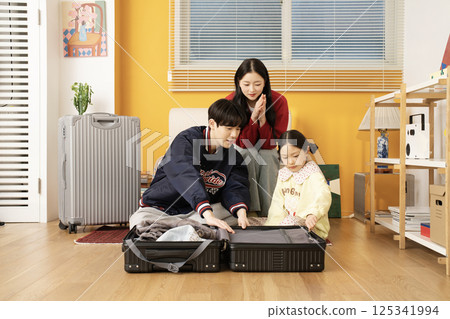 Mother and daughter sitting on the sofa and hugging their husband and father 125341994