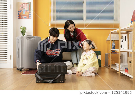 Mother and daughter sitting on the sofa and hugging their husband and father Mother and daughter sitting on the sofa and hugging their husband and father 125341995
