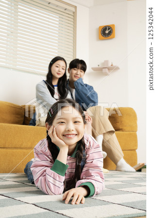 A family sitting in bed and reading a storybook A family sitting in bed and reading a storybook 125342044