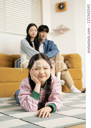 A family sitting in bed and reading a storybook A family sitting in bed and reading a storybook 125342045