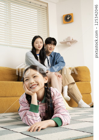 A family sitting in bed and reading a storybook A family sitting in bed and reading a storybook 125342046