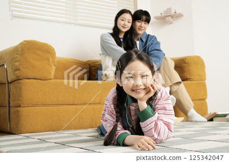 A family sitting in bed and reading a storybook A family sitting in bed and reading a storybook 125342047