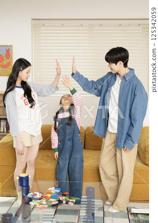 Portrait of family sitting on bed and stretching in the morning Portrait of family sitting on bed and stretching in the morning 125342059