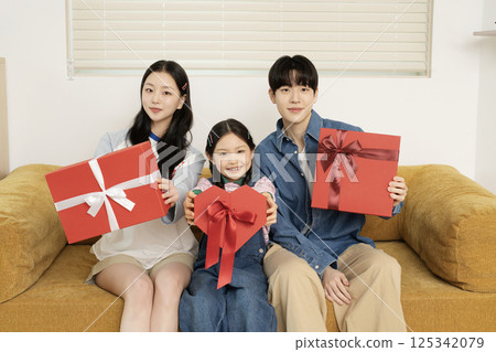 A family taking a photo while lying in bed 125342079