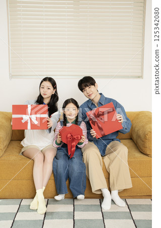 A family taking a photo while lying in bed 125342080