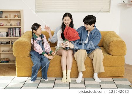 A family taking a photo while lying in bed 125342083