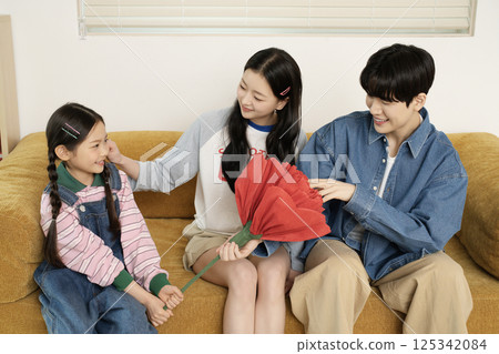 A family taking a photo while lying in bed 125342084