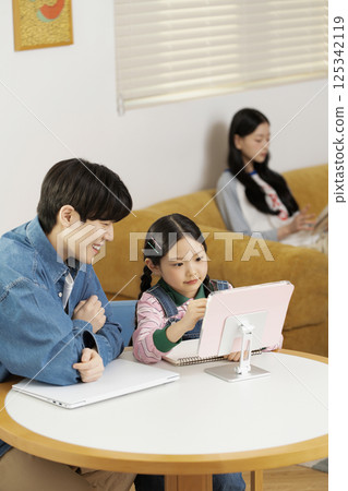 Dad sitting on bed with daughter 125342119