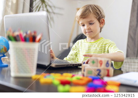 Child using laptop for online learning 125342915