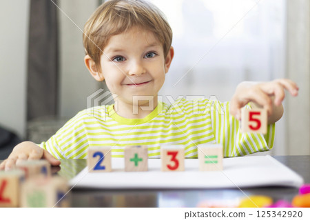 Smiling child learning math with blocks 125342920
