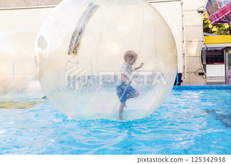 Child playing inside water walking ball 125342938