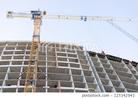 High-rise building under construction with cranes High-rise building under construction with cranes 125342943