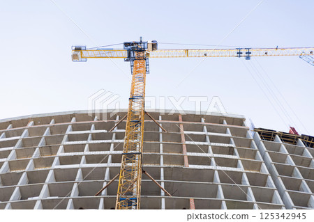 Construction crane above unfinished concrete building 125342945