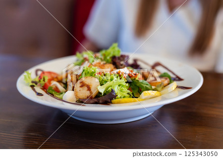 Grilled scallop salad with lemon slices 125343050